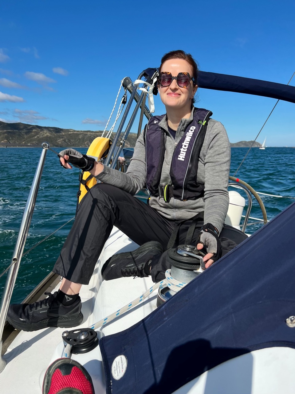 Heather at the winch of a sailboat on a bright day