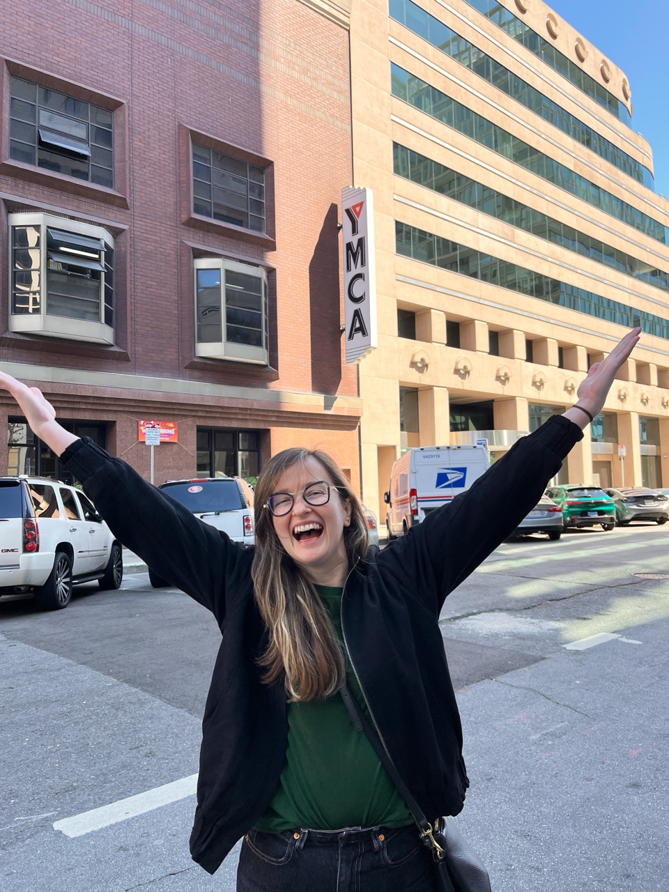 Heather with both arms in the air outside the YMCA